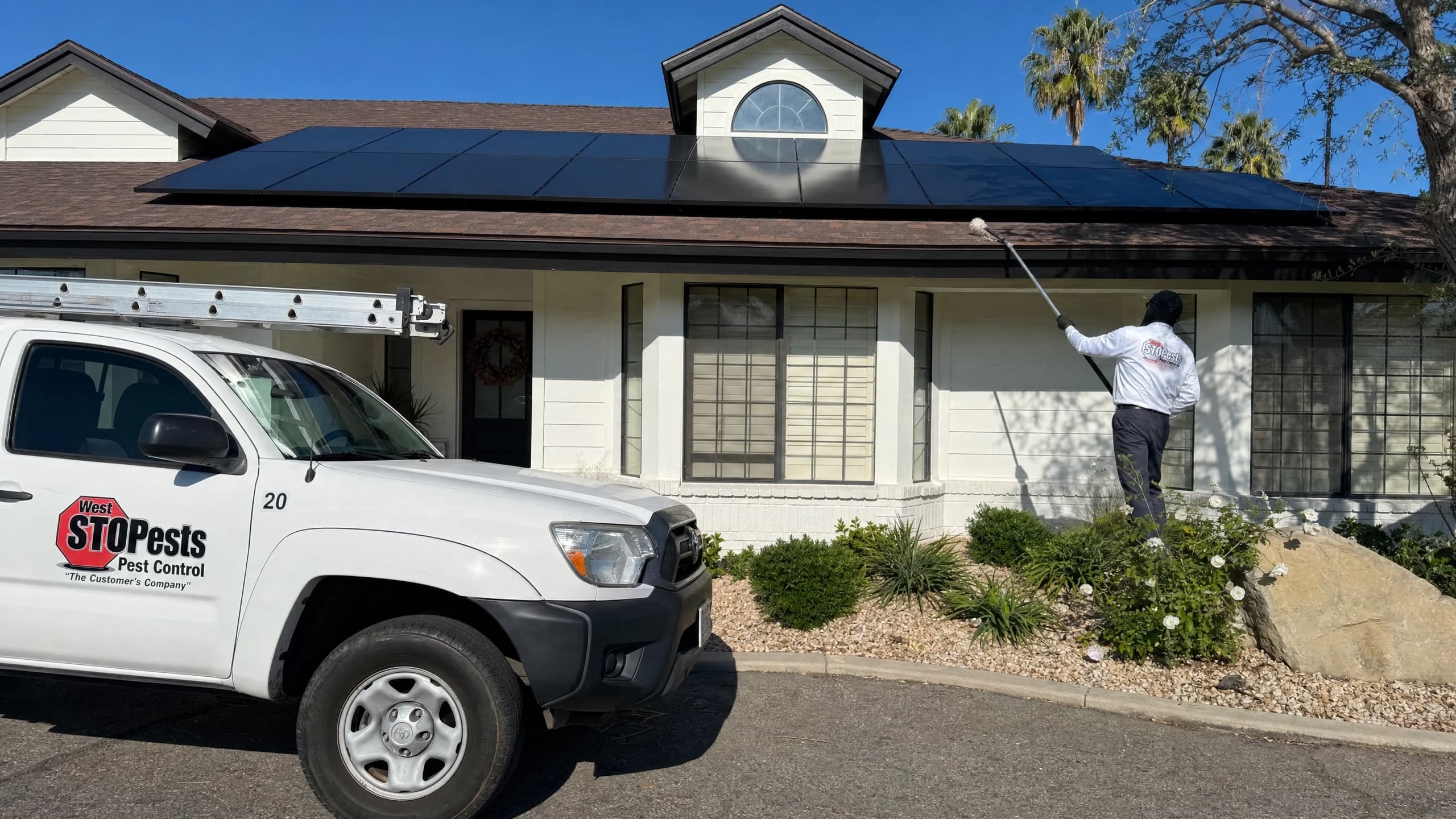 West STOP Pests technician treating the eaves of a home with solar panels in Arroyo Grande